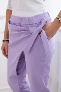 Trousers tied with an asymmetrical light purple front